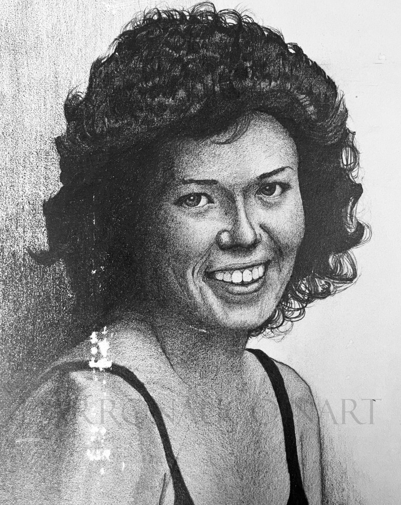 Black and white portrait of a smiling woman with curly hair, looking directly at the viewer.